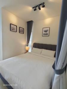a bedroom with a white bed and a window at The ocean city view in Kota Kinabalu