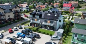 dom z samochodami zaparkowanymi na parkingu w obiekcie VILLA LIGHTHOUSE - Adults Only - 12plus w mieście Krynica Morska