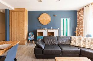 a living room with a black couch and a table at Les Boisés à Kaysersberg+ 1 place de parking in Kaysersberg