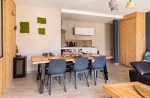 a dining room with a large wooden table and chairs at Les Boisés à Kaysersberg+ 1 place de parking in Kaysersberg