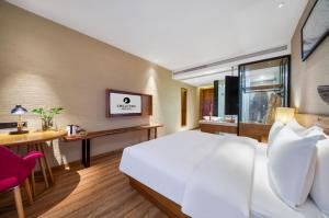 a hotel room with a large bed and a desk at 杭州忆栖生态艺术酒店西溪湿地店 in Hangzhou