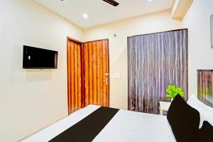 a bedroom with a bed and a flat screen tv at Hotel O Shree Jee Inn Guest House in Gurgaon +21 photos