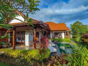 a house with a swimming pool in front of it at Villa Maya Ubud, Peaceful Rice Field View in Ubud