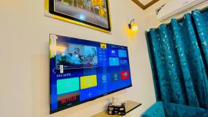 a flat screen tv hanging on a wall at Go Guest House Lahore in Lahore