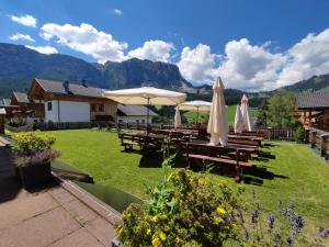a group of picnic tables with umbrellas on a lawn at Hotel San Leonardo in Badia