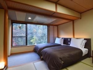 Postel nebo postele na pokoji v ubytování 式部のやかた井筒屋