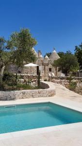 - une piscine en face d'une maison en pierre dans l'établissement Case Vacanza La Vita A Cono, à Cisternino