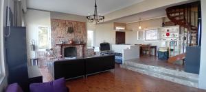 a living room with a fireplace and a kitchen at Aperando in Tolo