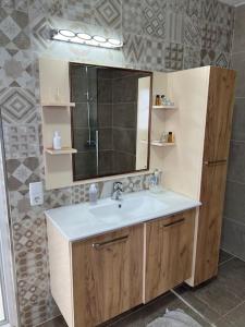 a bathroom with a sink and a mirror at komplettes Haus mit moderner Ausstattung in ruhiger Lage in Gjilan