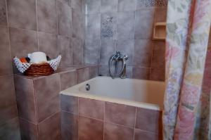 a bathroom with a tub and a shower curtain at sunrayhouse Arkasa in Arkasa +50 photos