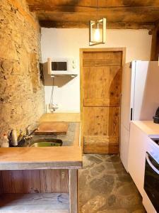a kitchen with a sink and a white refrigerator at Maison typique rénovée 4 CHBR lac d'Oô Peyragudes in Oô