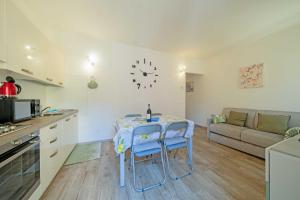 Una cocina y una sala de estar con una mesa y un sofá. en ApartmentsGarda - Residenza Emanuele, en Torri del Benaco