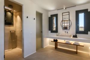 a bathroom with a sink and a mirror at Regency Sunset Suites in Mýkonos City +41 photos