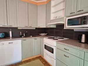 a kitchen with white cabinets and a white stove top oven at Ainola 2 in Syöte