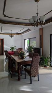 a dining room with a wooden table and chairs at Verano GuestHouse Your convenient Place to stay in Tagbilaran City in Pooc