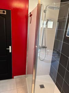 a bathroom with a glass shower with a red door at Made in Beaufort in Beaufort-en-Vallée +10 photos