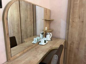 a table with two mugs and a mirror on it at Hotel Old Star in Batumi