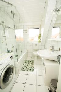 ein weißes Badezimmer mit einer Waschmaschine und einem Waschbecken in der Unterkunft Ferienwohnung Emilia in Speyer