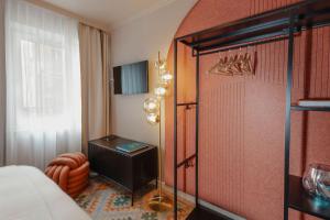 a bedroom with a bed and a dresser in a room at Hotel Lux in Munich