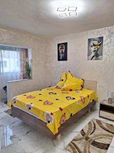 a bedroom with a yellow bed with a yellow comforter at Apartament TIMEEA Baile Herculane in Băile Herculane