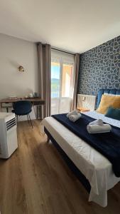 a bedroom with a bed and a desk and a window at Hôtel Restaurant du Lac in Boussens