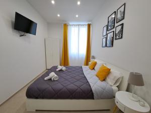 a bedroom with a bed with towels on it at Le Popolari - Appartamento in Bitonto