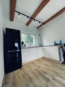 a kitchen with a black refrigerator and a wooden floor at Dom-na Mazury! in Mrągowo +8 photos