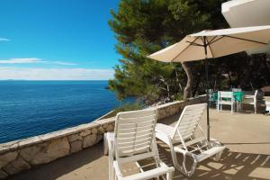 2 sillas y una sombrilla en un patio con vistas al océano en Apartments Bisko, en Prizba
