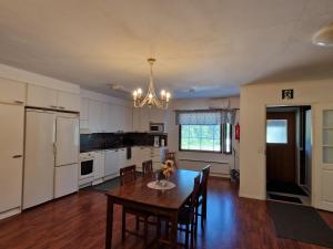 a kitchen with a wooden table and a dining room at Ainola 1 in Syöte