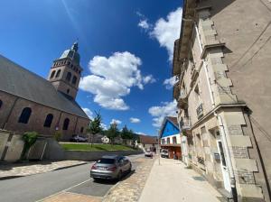 a car parked next to a building with a clock tower at Studio façon chalet montagnard - Hyper centre in Gérardmer