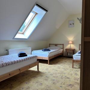 a attic bedroom with two beds and a window at Landferienwohnung 1 Danneborth in Danneborth