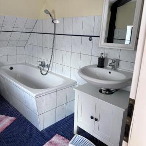 a bathroom with a sink and a bath tub and a sink at Landferienwohnung 1 Danneborth in Danneborth