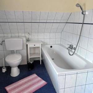 a bathroom with a white tub and a toilet at Landferienwohnung 1 Danneborth in Danneborth +7 photos