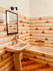 a bathroom with a sink and a tub and a mirror at Alexiou Studios in Loutra Edipsou +50 photos