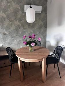a dining room table with a vase of flowers on it at Apartamenty Św Stanisława in Skierniewice +52 photos