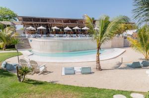 a resort with a pool and chairs and a palm tree at Le Pirate Gili Meno - Adults Only in Gili Meno