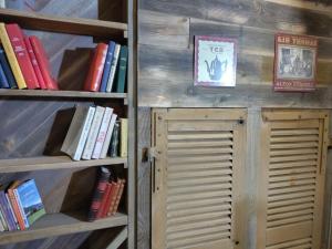 a book shelf filled with books next to a door at Les Renardières - Usson en Forez in Usson-en-Forez
