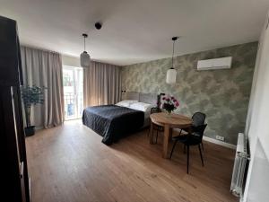 a bedroom with a bed and a table with flowers on it at Apartamenty Św Stanisława in Skierniewice