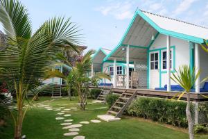 a blue and white house with a wooden deck at Le Pirate Gili Meno - Adults Only in Gili Meno