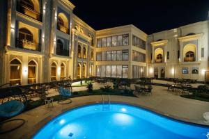- un grand bâtiment avec une piscine la nuit dans l'établissement Kohinur Plaza, à Samarcande