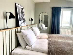 un letto con cuscini bianchi in una camera da letto di Hotel Isbolaget a Donsö