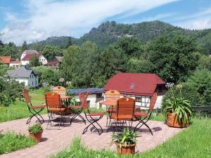 a group of chairs and tables on a patio at Ferienpension Gabriele in Kurort Gohrisch