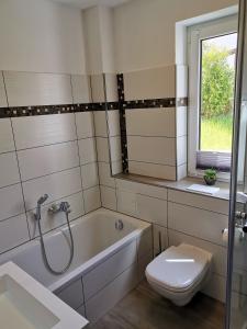 Un baño con bañera, inodoro y lavabo. en Apartment in Papstdorf "Rübezahlstiege", en Kurort Gohrisch