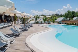 a pool at a resort with chairs and umbrellas at Le Pirate Gili Meno - Adults Only in Gili Meno