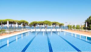 a large swimming pool with chairs and trees and water at HA Hotel in Bracciano