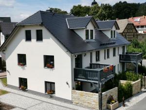 una casa blanca con techo negro en Apartment in Papstdorf "Rübezahlstiege", en Kurort Gohrisch