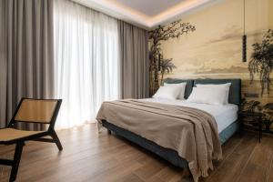 une chambre avec un grand lit et une chaise dans l'établissement La Siesta Villas, à Ixia 23 autres photos