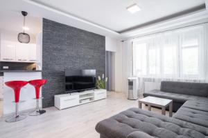 Una sala de estar con un sofá y un televisor de pantalla plana. en Apartment Karadzicova, en Bratislava