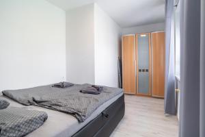 Un dormitorio blanco con una cama y un armario. en Apartment Karadzicova, en Bratislava