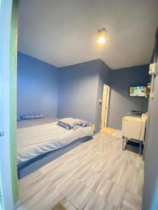 格兰岛MD Kohlarn-Pattaya的一间带床和蓝色墙壁的卧室